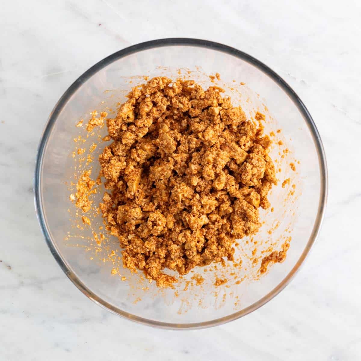 Tofu crumbles with marinade in a bowl.