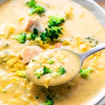 Spoon taking vegan broccoli cheddar soup from a bowl.