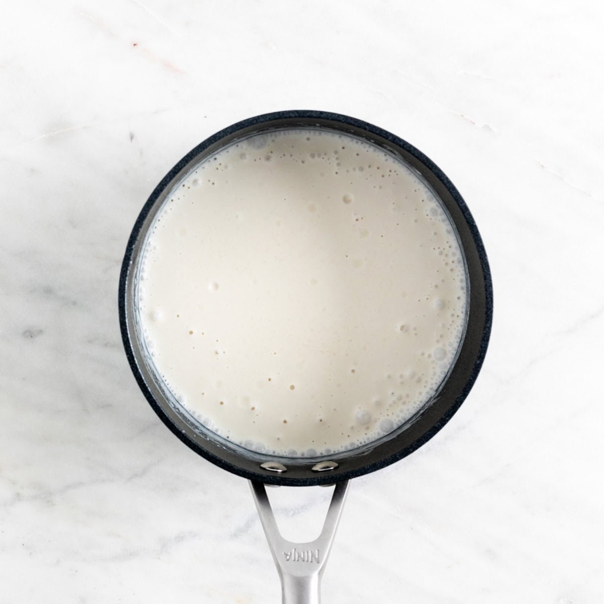 Ingredients for vegan panna cotta mixed in a saucepan.