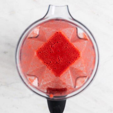 Strawberry coulis mixture blended in a blender jar.