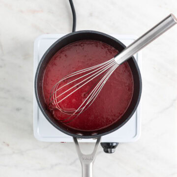 Cooked strawberry coulis in a saucepan.