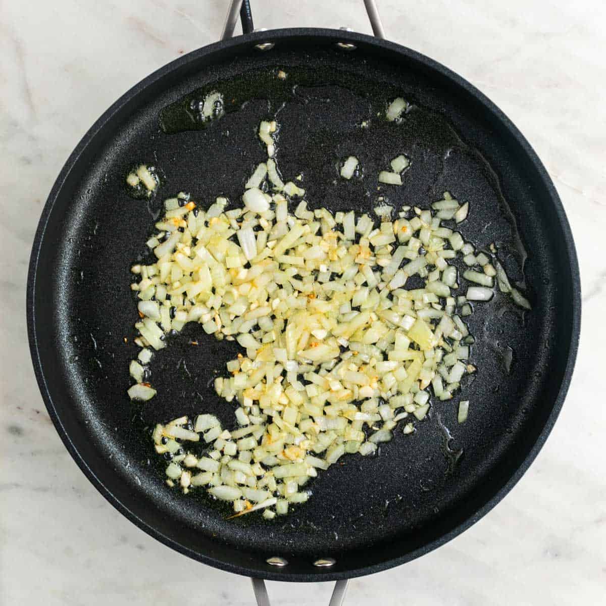 Sautéed onion and garlic in a skillet.