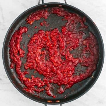 Sautéed onion, garlic, tomato paste, salt, pepper, and vodka in a skillet.