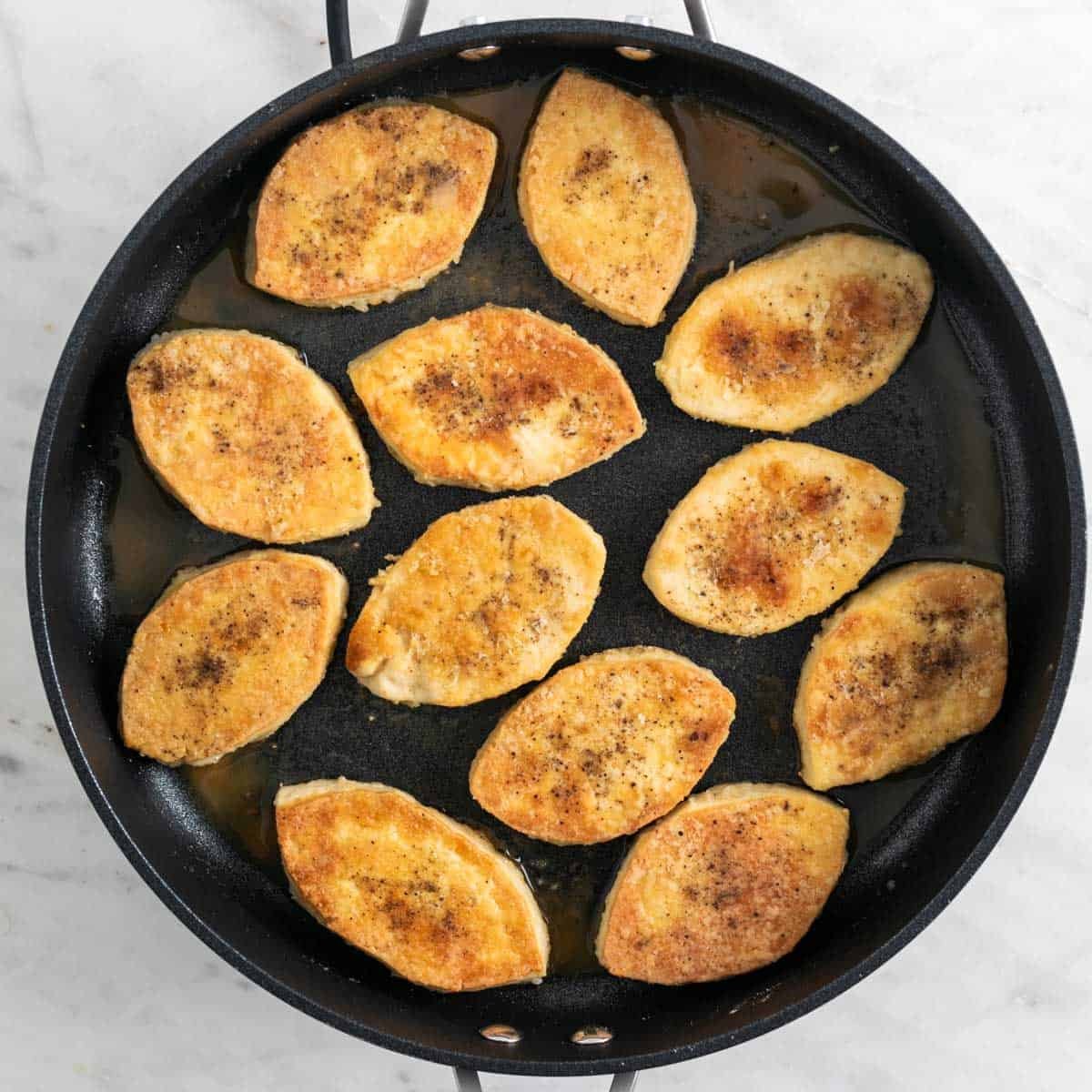 Tofu filets sautéed in a skillet.