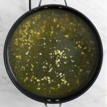 Garlic sautéed in a skillet with vegetable stock.