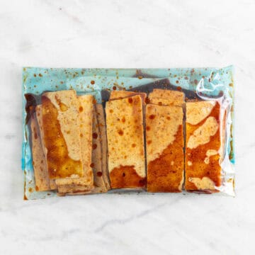 Sliced tofu marinating in a sealable freezer bag.