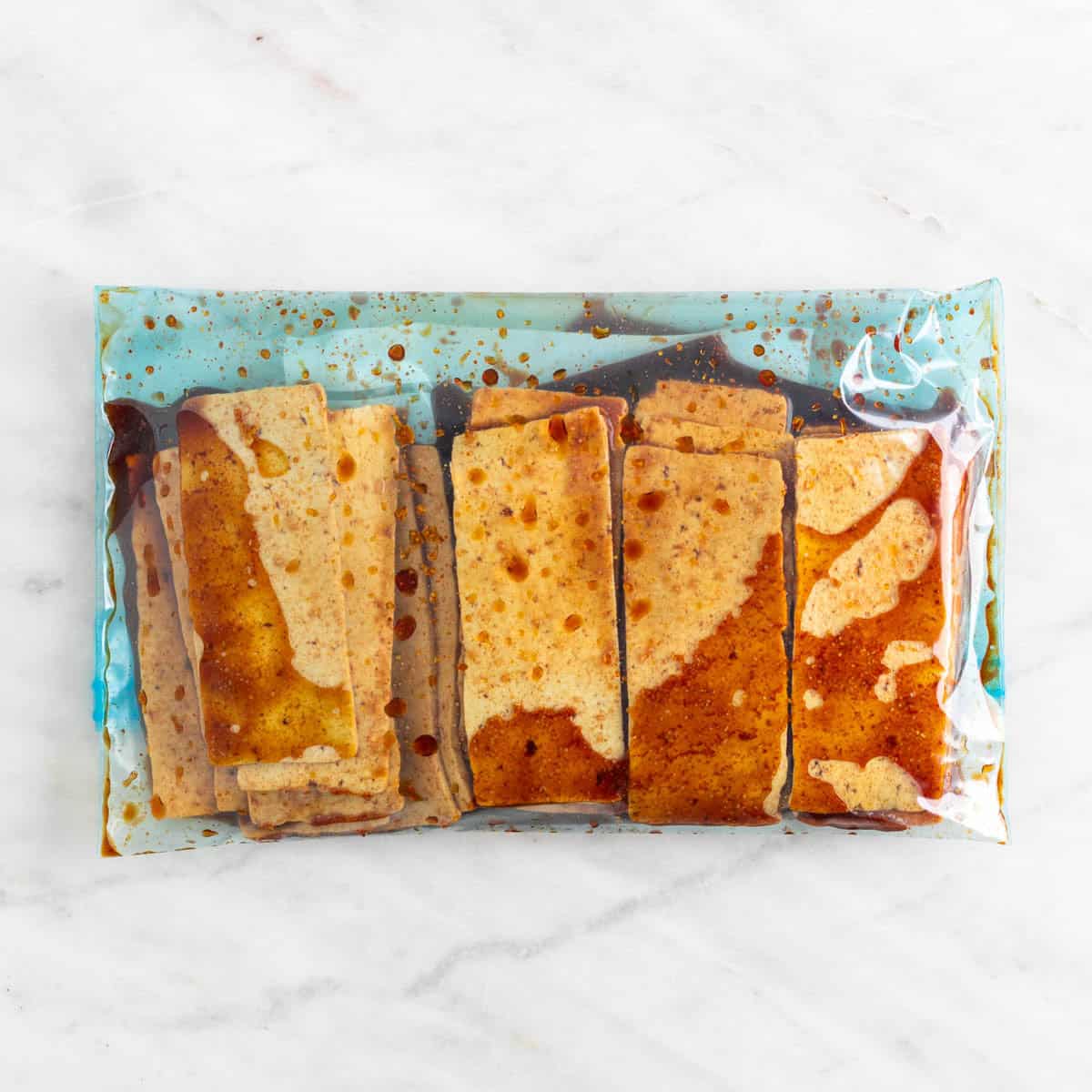 Sliced tofu marinating in a sealable freezer bag.