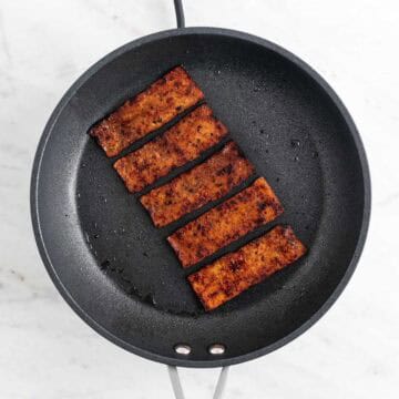 Cooked tofu bacon in a skillet.