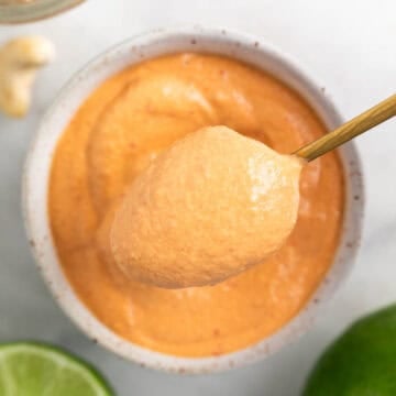Spoon taking vegan chipotle sauce from a bowl.