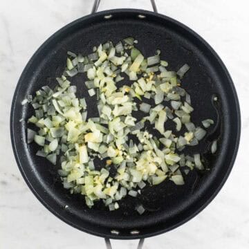 Sautéed onion and garlic in a skillet.
