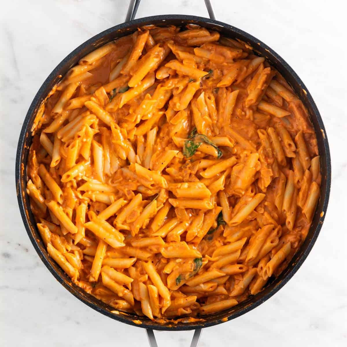 Vegan pasta sauce in a skillet with penne.