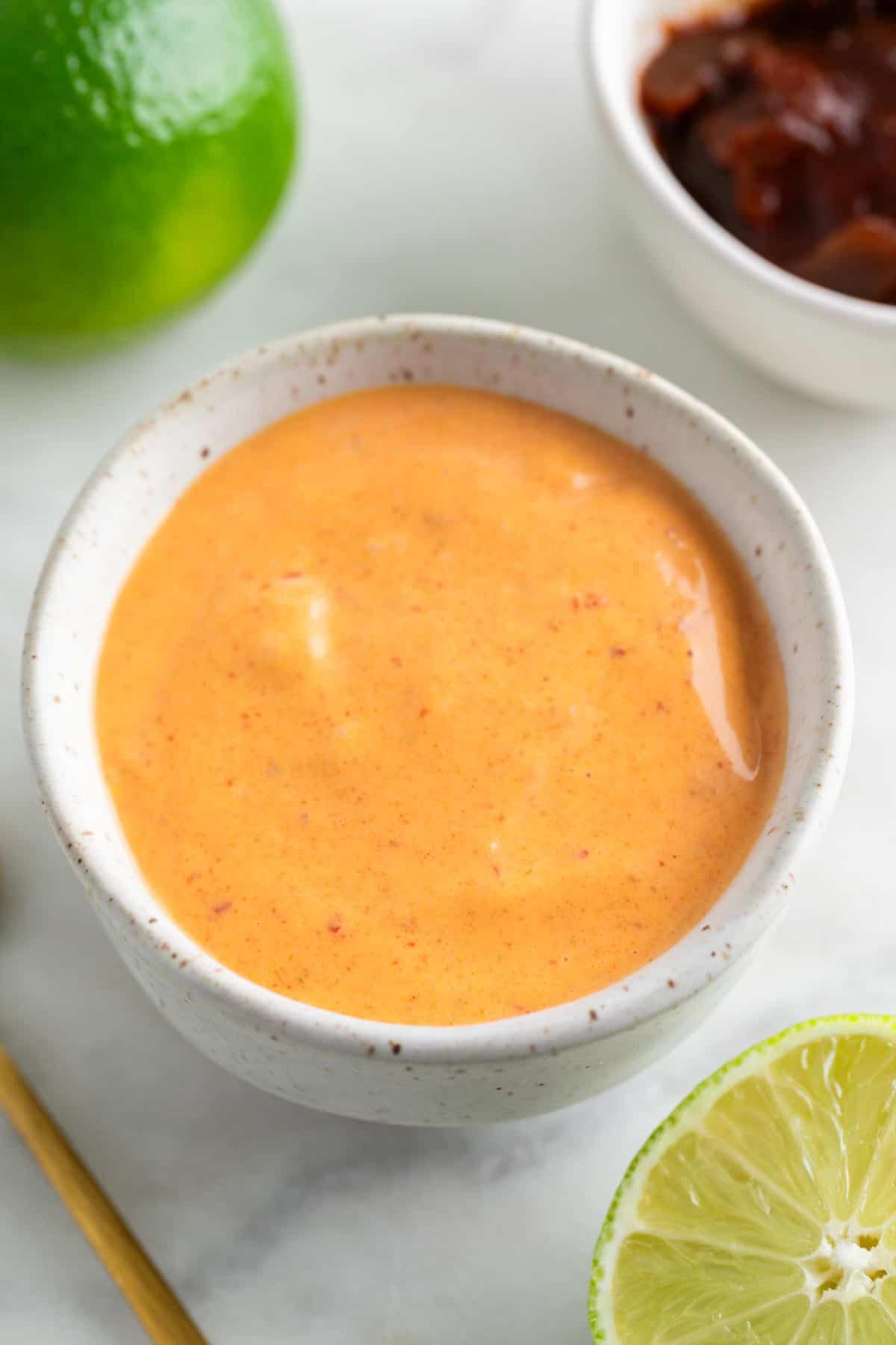 Vegan chipotle mayo in a bowl surrounded by ingredients.