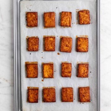 Baked tofu slices in a lined baking dish.