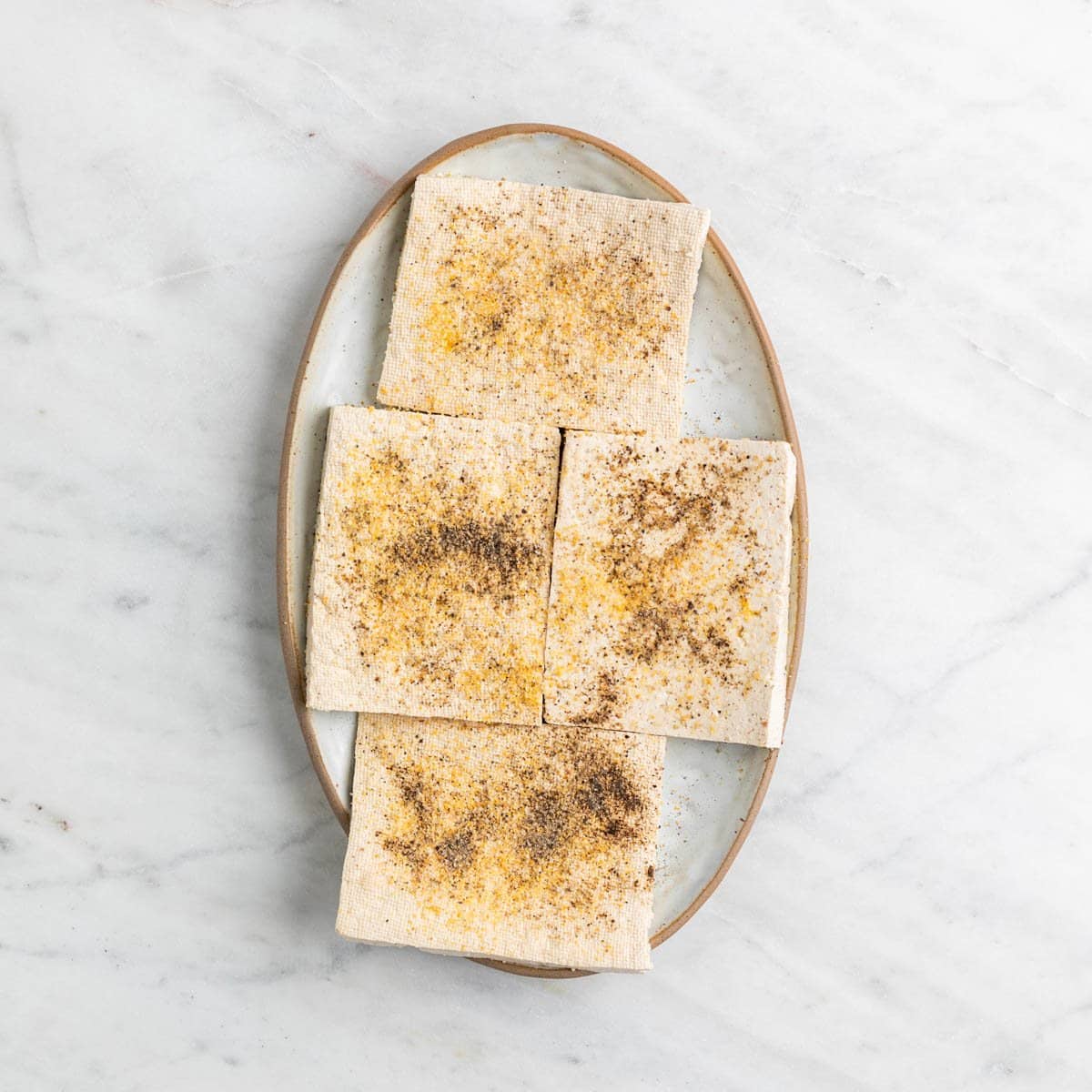 Seasoned tofu pieces on a plate.