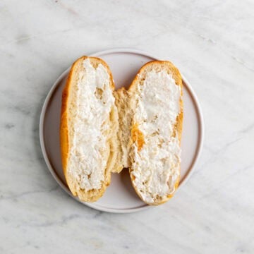 Toasted sandwich roll spread with vegan mayo.
