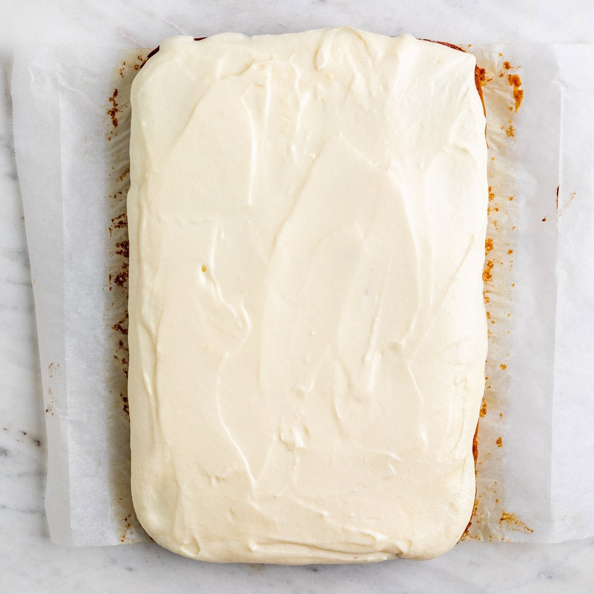 Baked vegan pumpkin cake with vegan cream cheese frosting.