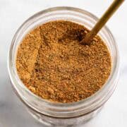 Homemade chicken seasoning blend in a jar with a spoon.