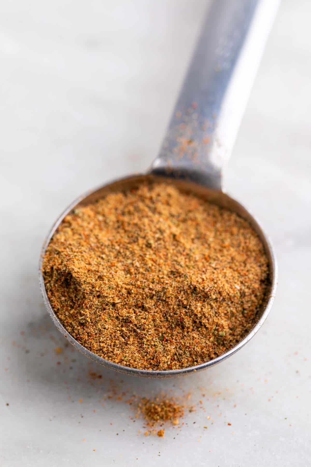 Spoon with chicken seasoning blend.