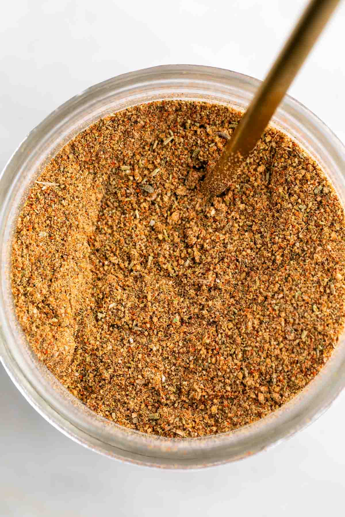 Chicken seasoning blend in a jar with a spoon.