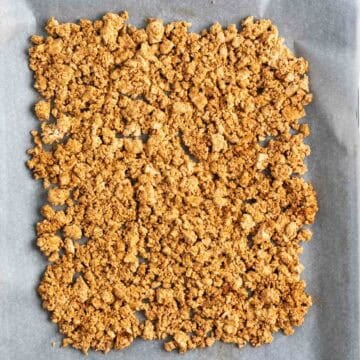 Tofu crumbles on a baking sheet before baking.