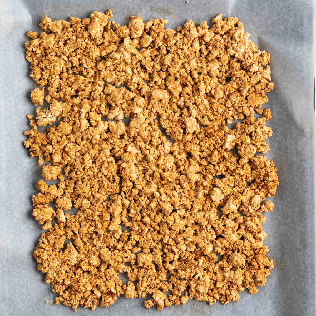 Tofu crumbles on a baking sheet before baking.