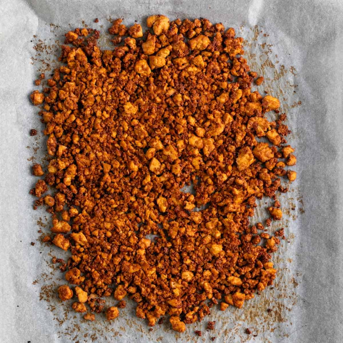Baked tofu crumbles on a baking sheet.