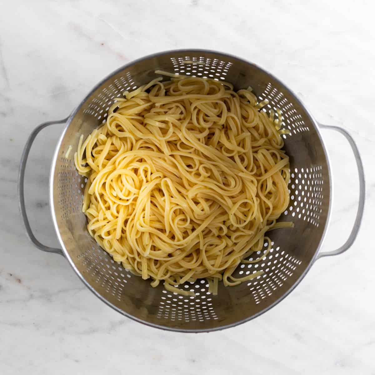 Cooked spaghetti in a colander.