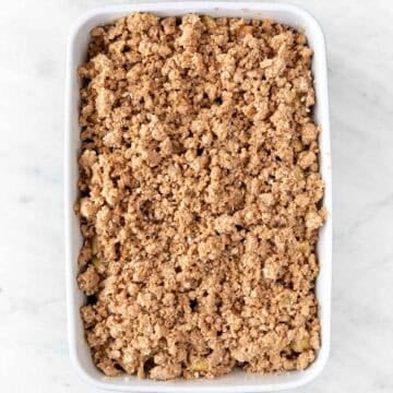 Baking dish with vegan apple crisp before baking.