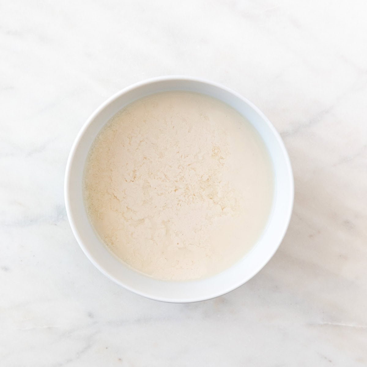 A bowl with non-dairy milk and vinegar mixture.