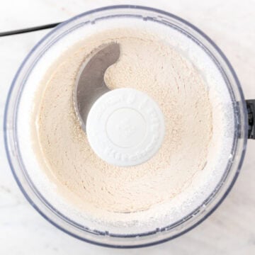 The flour, baking powder, sugar, and salt are just combined in the food processor bowl.