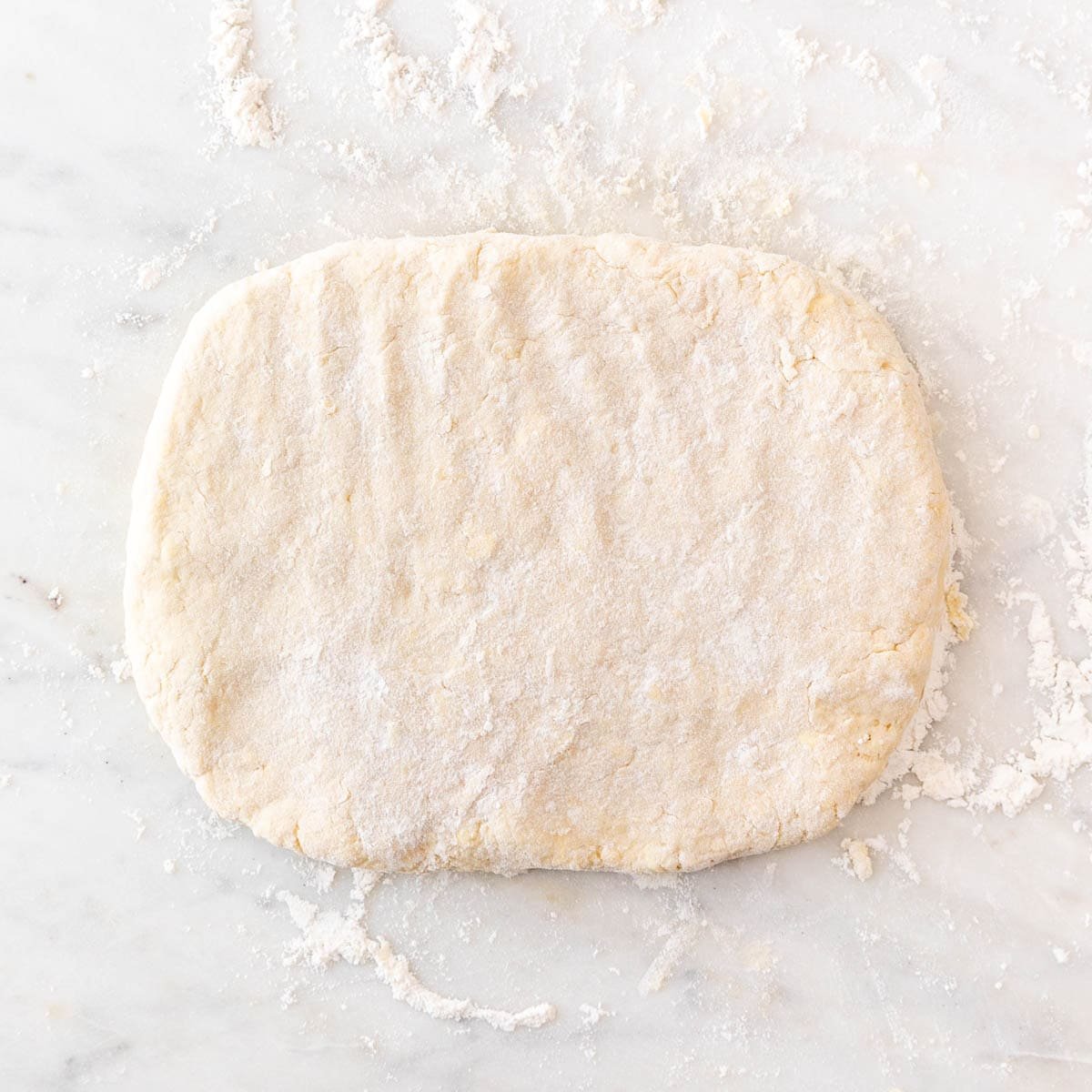 Vegan biscuit dough flattened into a thick rectangle.