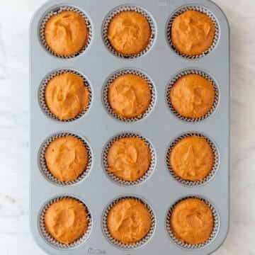 Muffin pan with vegan pumpkin batter.