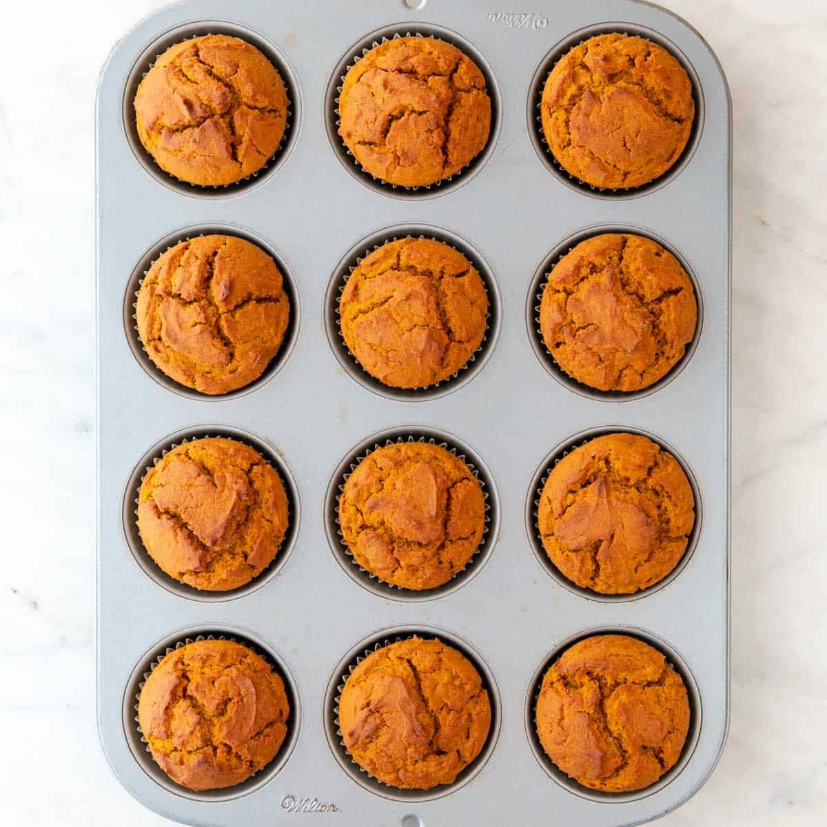 Vegan pumpkin muffins in a muffin pan.