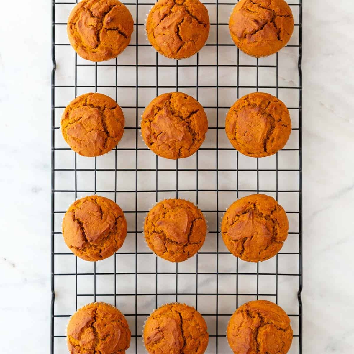 Vegan pumpkin muffins on a cooling rack.