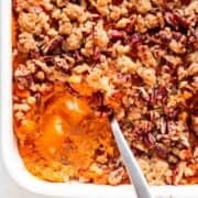 Scooped vegan sweet potato casserole from a baking dish.