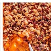 A scoop removed from a baking dish of vegan sweet potato casserole.