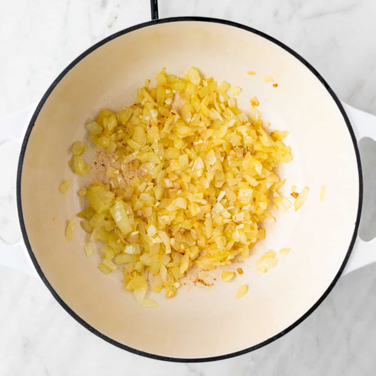 Sautéed onion and garlic cooked in a pot until golden and fragrant.