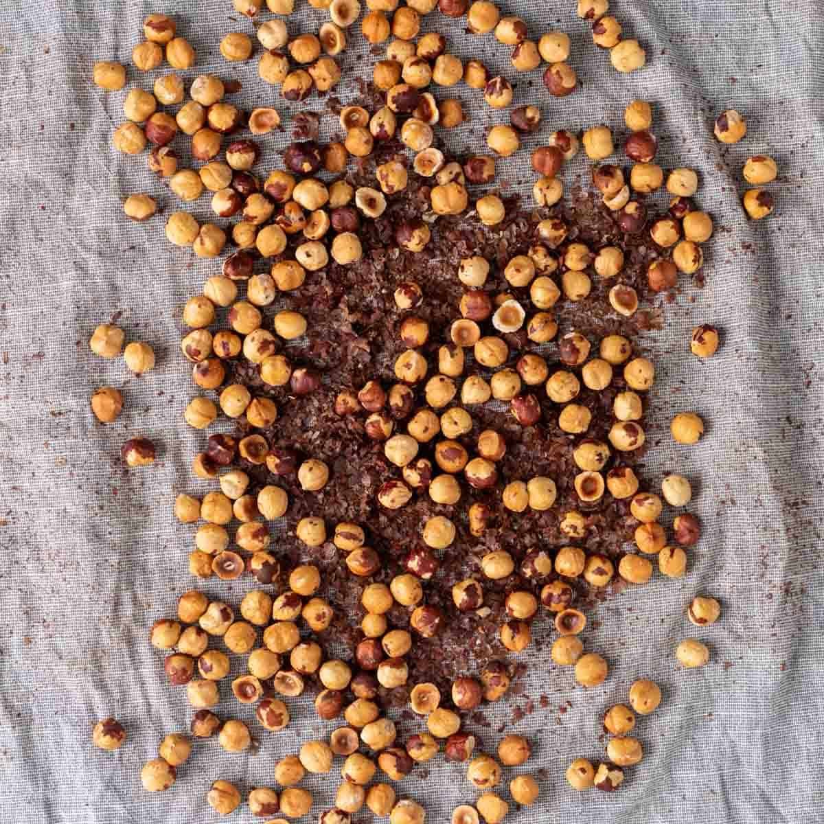 Hazelnuts with the skins removed on a kitchen towel.
