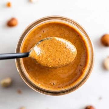 Spoonful of hazelnut butter over a jar.