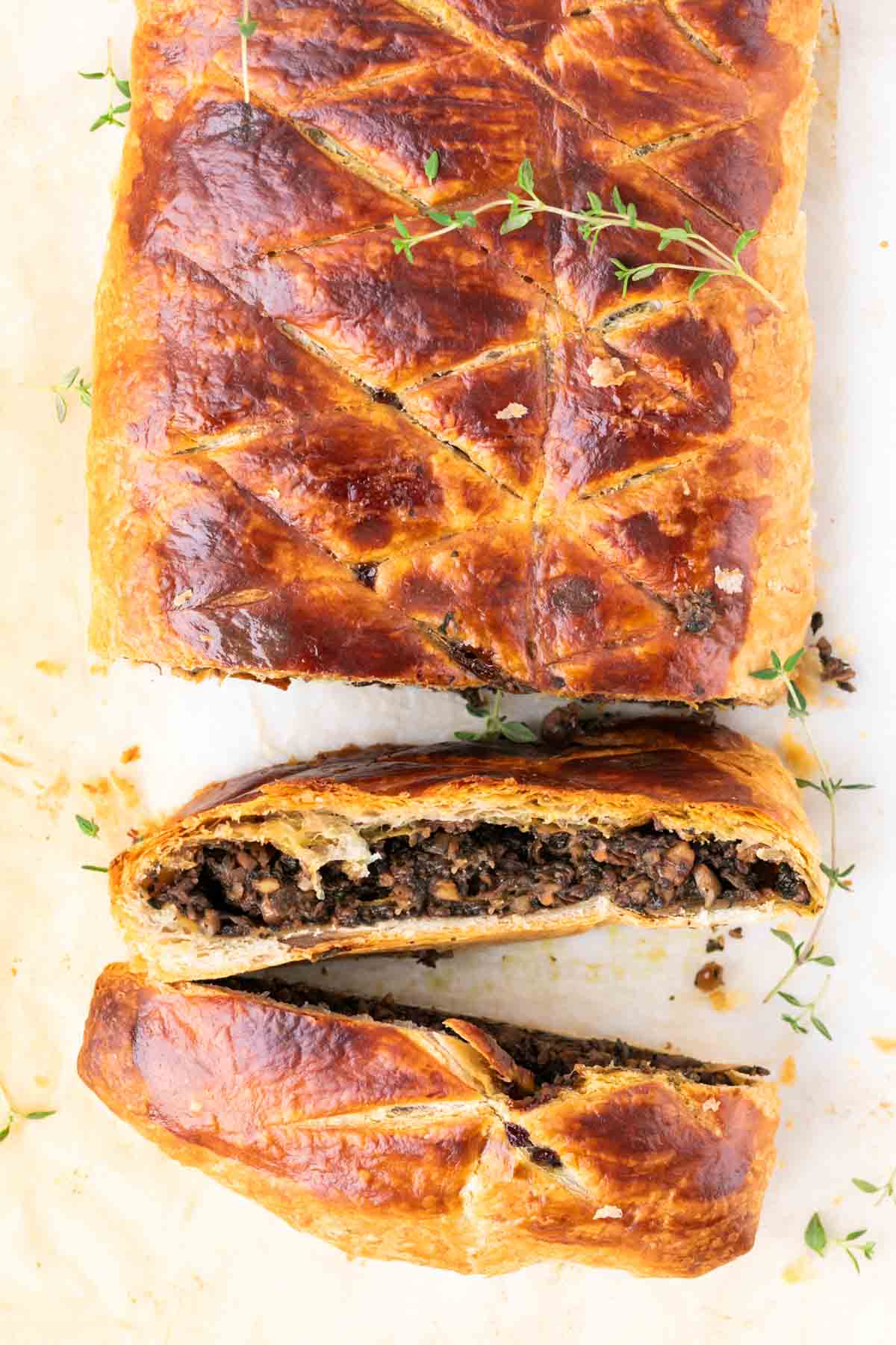 Vegan mushroom wellington baked and partially sliced.