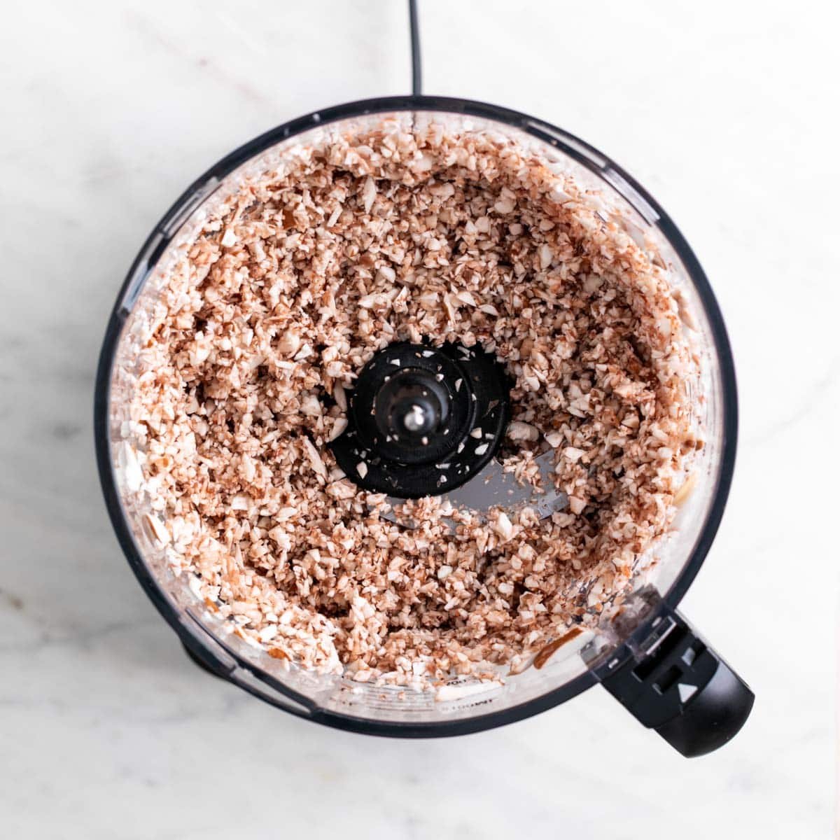 Finely chopped mushrooms with a crumbly texture in a food processor.