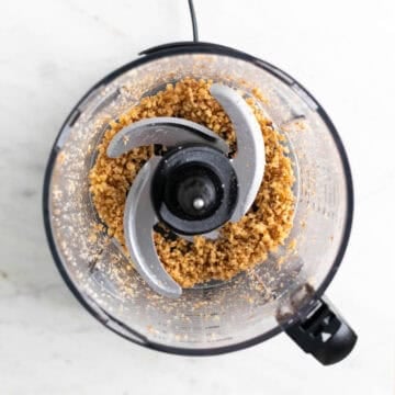 Crumbly chopped walnuts processed in a food processor.
