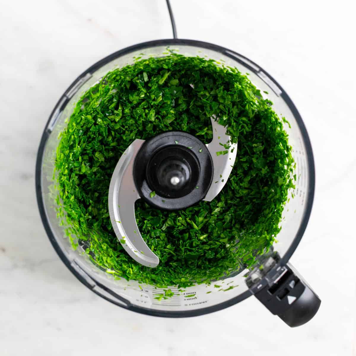 Finely chopped spinach in a food processor.