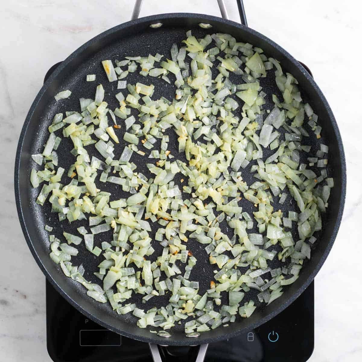 Sautéed onion and garlic lightly browned in a skillet.