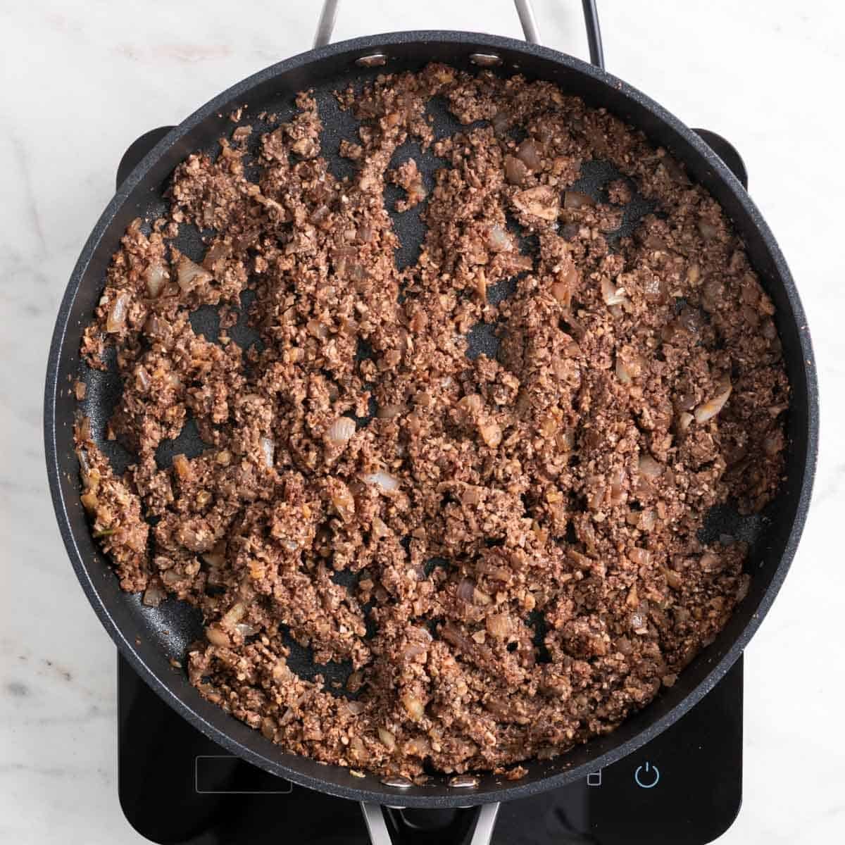 Mushroom and walnut mixture cooking down with reduced liquid.