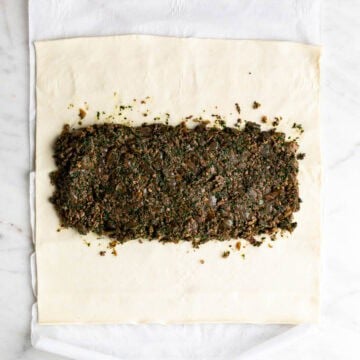 Mushroom filling spread down the center of puff pastry.