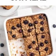 Vegan baked oatmeal cut into portions in a baking dish, with one slice removed.