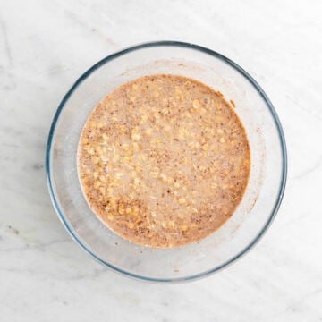 Vegan baked oatmeal ingredients mixed in a large bowl, excluding the blueberries.