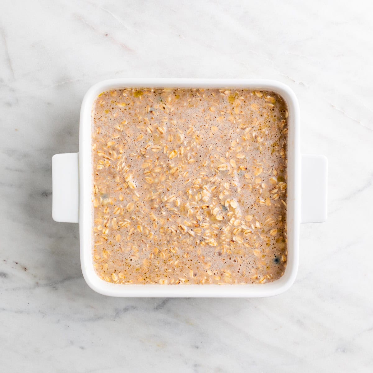 Vegan baked oatmeal mixture transferred to a baking dish.