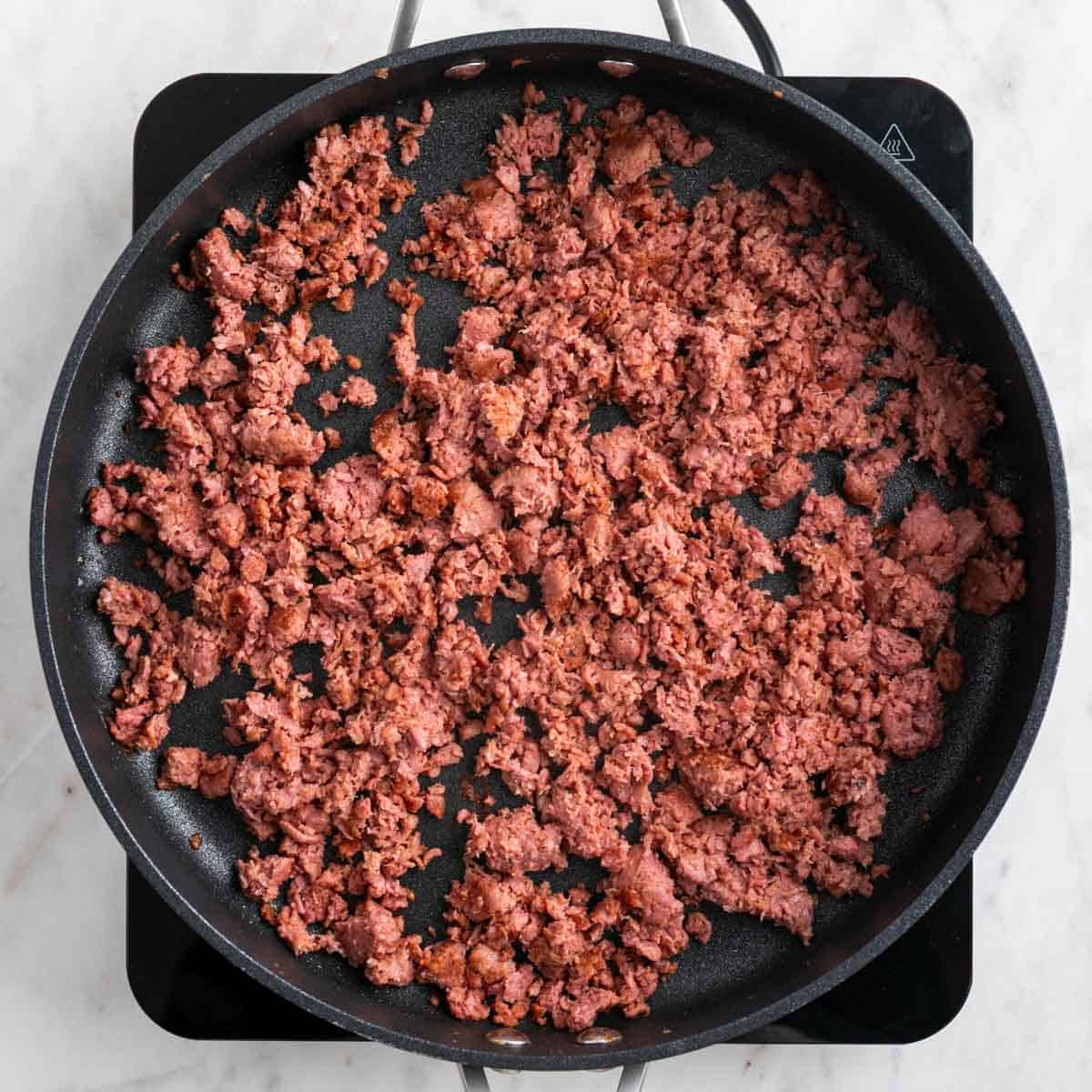 Cooked vegan sausage in a skillet.